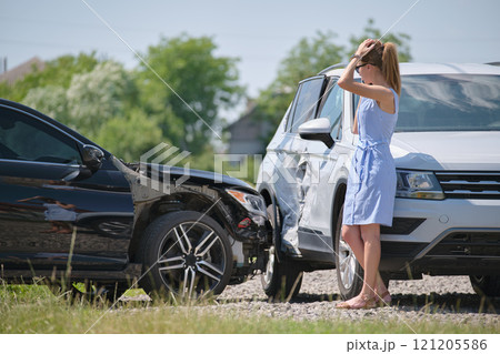 Sad female driver speaking on sellphone on street side calling for emergency service after car accident. Road safety and insurance concept 121205586