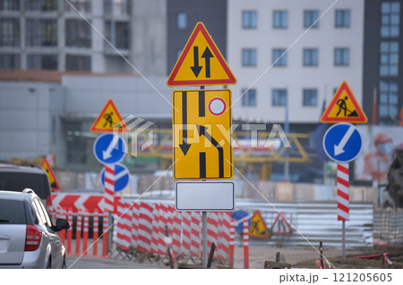 Roadworks warning traffic signs of construction work on city street and slowly moving cars Roadworks warning traffic signs of construction work on city street and slowly moving cars 121205605