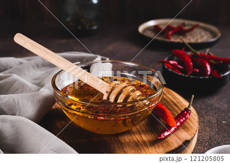 Hot honey chili sauce in bowl on table 121205805