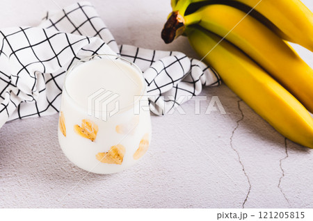 Banana vegan alternative milk in glass and fruits on table Banana vegan alternative milk in glass and fruits on table 121205815