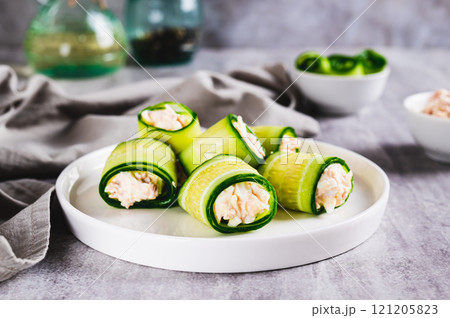 Appetizing cucumber rolls made from tuna salad, egg and cheese on a plate on the table Appetizing cucumber rolls made from tuna salad, egg and cheese on a plate on the table 121205823