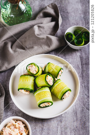 Cucumber rolls with fish salad on a plate on the table vertical view Cucumber rolls with fish salad on a plate on the table vertical view 121205826