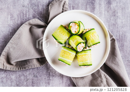 Close up of appetizing cucumber rolls made from tuna salad, egg and cheese on a plate top view Close up of appetizing cucumber rolls made from tuna salad, egg and cheese on a plate top view 121205828
