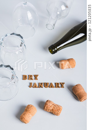 Overturned glasses, empty bottles, corks and text dry january on gray vertical view Overturned glasses, empty bottles, corks and text dry january on gray vertical view 121205835