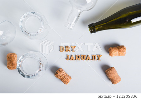 Dry January concept, empty glasses, bottles and corks on a gray background top view Dry January concept, empty glasses, bottles and corks on a gray background top view 121205836
