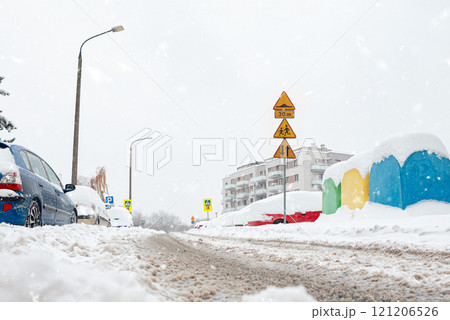 Poland, Krakow, 12.03.2023, snowfall, snowy street with cars after a blizzard Poland, Krakow, 12.03.2023, snowfall, snowy street with cars after a blizzard 121206526