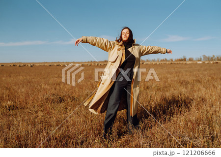 Young woman in stylish clothes posing in autumn field. Nature, fashion, lifestyle. Travel. 121206666