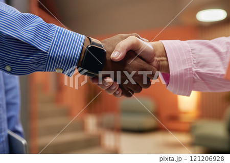 Side view of two female and male business partner shaking hands making successful deal at meeting in working environment, copy space Side view of two female and male business partner shaking hands making successful deal at meeting in working environment, copy space 121206928