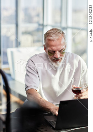 Vertical shot of mature man with hydrogel patches under eyes taking care of face skin 121208232