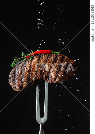 cooking meat steak and adding salt, grilled steak. vertical image. copy space for text cooking meat steak and adding salt, grilled steak. vertical image. copy space for text 121208842