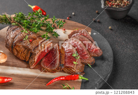 Sliced grilled beef barbecue Striploin steak on a dark background. top view Sliced grilled beef barbecue Striploin steak on a dark background. top view 121208843