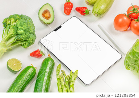 tablet with white screen for mock up with vegetarian healthy food vegetable background, shopping delivery app, cook book diet plan nutrition recipes 121208854