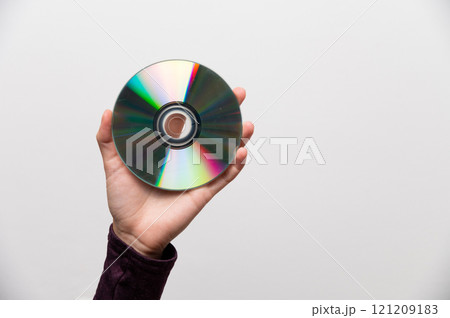 Image of a hand holding a CD, a metaphor for data protection. CD in a woman's hand, old technology 121209183