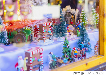 Miniature Christmas village scene with trees and figurines in window . Concept of festive decoration, winter holiday Miniature Christmas village scene with trees and figurines in window . Concept of festive decoration, winter holiday 121209392