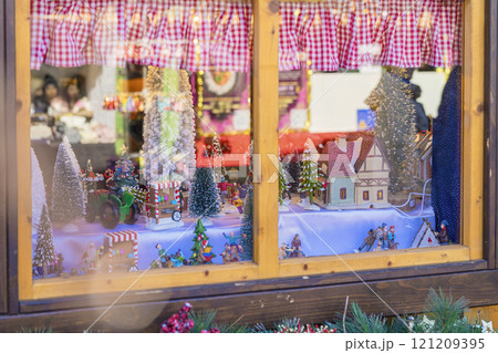 Holiday display featuring miniature winter village in shop window decorated for the festive season Holiday display featuring miniature winter village in shop window decorated for the festive season 121209395