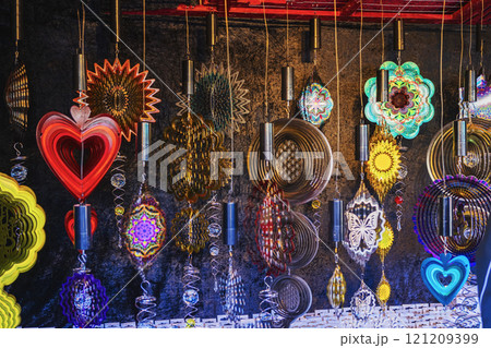 Colorful wind spinners displayed in market stall. Concept of vibrant decoration, creative ornaments 121209399