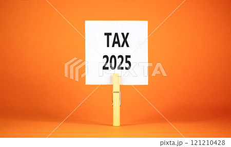 Planning tax 2025 new year symbol. Concept words Tax 2025 on beautiful white paper on wooden clothespin. Beautiful orange background. Business tax 2025 new year concept. Copy space. Planning tax 2025 new year symbol. Concept words Tax 2025 on beautiful white paper on wooden clothespin. Beautiful orange background. Business tax 2025 new year concept. Copy space. 121210428