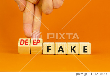 Deepfake or fake symbol. Concept words Fake Deepfake on wooden cubes. Beautiful orange table orange background. Businessman hand. Business and deepfake or fake concept. Copy space. 121210643