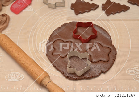 Christmas homemade baking, dough cut for baking gingerbread, cutter, rolling pin, spatula on the table 121211267