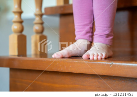 Closeup of little girl feet going down the stairs at home Closeup of little girl feet going down the stairs at home 121211453