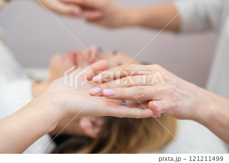 Close up view of healer launches body energy through hands before access bars therapy with young woman, stimulating positive change thoughts and emotions. Alternative medicine concept. 121211499