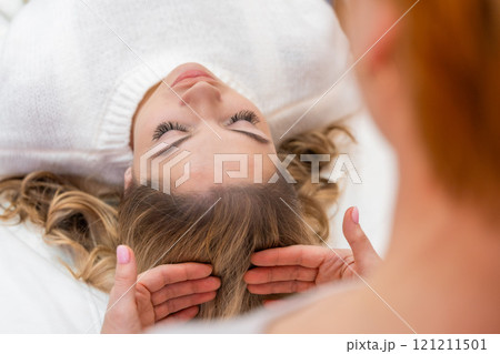 Healer performing by lightly touched set of 32 points of access bars on woman head, stimulating positive change thoughts and emotions. Alternative medicine Healer performing by lightly touched set of 32 points of access bars on woman head, stimulating positive change thoughts and emotions. Alternative medicine 121211501