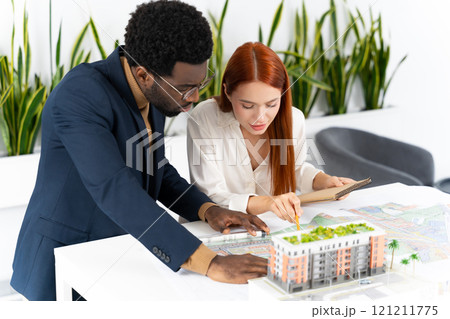 Colleagues in the office working together and looking involved Colleagues in the office working together and looking involved 121211775