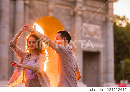 Couple dancing swing in front of puerta de alcala in madrid at sunset 121212415