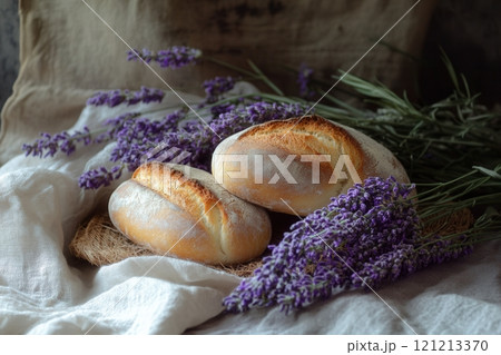 Two freshly baked loaves resting on a table with lavender flowers 121213370