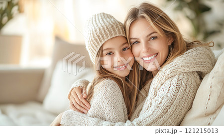 仲良くソファに座って寄り添う白人の母親と女の子 121215013