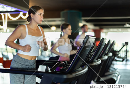 Young woman exercising on treadmill in gym Young woman exercising on treadmill in gym 121215754