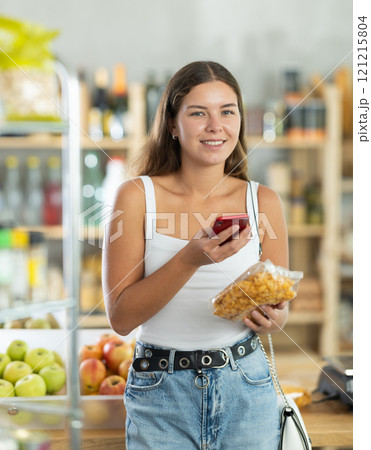 Young woman scanning qr code of corn flakes 121215804