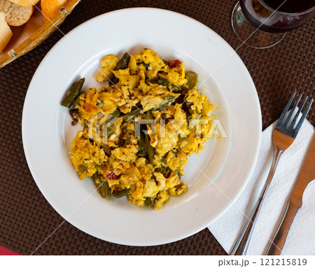 Scrambled eggs served with ham for breakfast 121215819