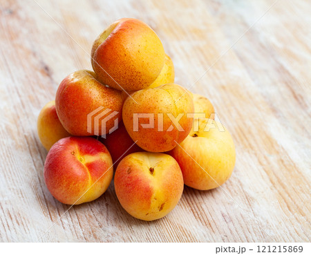 Heap of ripe reddish apricots on wooden table Heap of ripe reddish apricots on wooden table 121215869