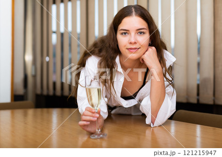 Portrait of sexy businesswoman with glass of wine at table 121215947