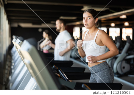 Young woman exercising on treadmill in gym 121216502