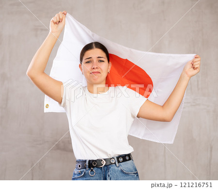 Irritated girl stands with flag of Japan. Isolated on gray background Irritated girl stands with flag of Japan. Isolated on gray background 121216751