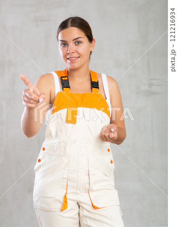 Portrait of happy emotional female builder or mechanic in overalls 121216934