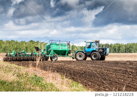 Tractor works in the field for sowing 121218228
