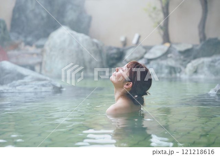 のんびり露天風呂に入る若い女性　撮影協力・白玉の湯 泉慶 121218616