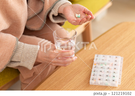 常用薬を飲むミドル〜シニア女性の手元 常用薬を飲むミドル〜シニア女性の手元 121219102