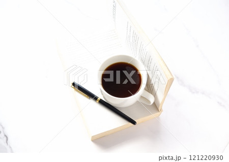 ページを開いた本(洋書)とコーヒーの入ったコーヒーカップで、コーヒーを飲みながら読書を楽しむイメージ ページを開いた本(洋書)とコーヒーの入ったコーヒーカップで、コーヒーを飲みながら読書を楽しむイメージ 121220930