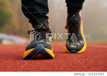 Runner wearing modern sport shoes standing on track surface 121221261