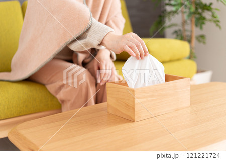 冬の部屋でティッシュを手にするミドル〜シニア女性 冬の部屋でティッシュを手にするミドル〜シニア女性 121221724