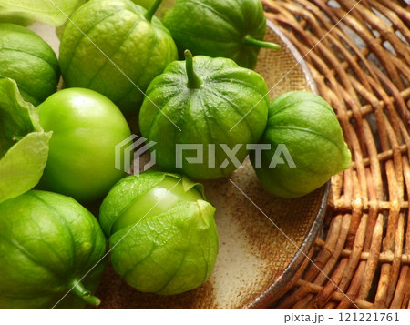 笊とお皿に乗せた、収穫した緑色のトマティーヨ 笊とお皿に乗せた、収穫した緑色のトマティーヨ 121221761