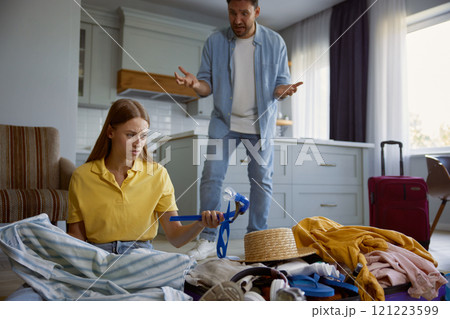 Couple quarreling because of clothing excess prepared for vacation Couple quarreling because of clothing excess prepared for vacation 121223599