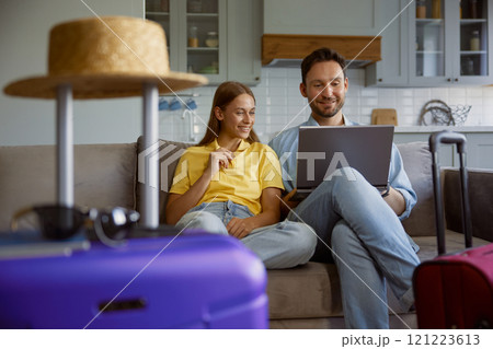Happy loving couple planning honeymoon tour searching flight ticket on internet Happy loving couple planning honeymoon tour searching flight ticket on internet 121223613