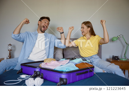 Joyful married couple planning vacation preparing clothes for travel Joyful married couple planning vacation preparing clothes for travel 121223645