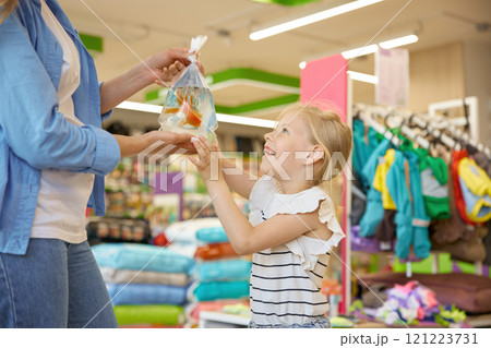 Happy satisfied mother and child buying new gold fish at pet shop 121223731