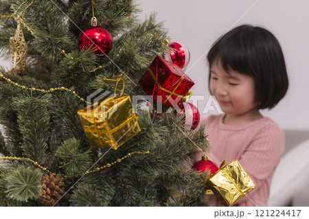 クリスマスツリーを飾りつける女の子 121224417